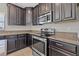 Kitchen with stainless steel appliances and dark wood cabinets at 5048 Ivory Stone Dr, Wimauma, FL 33598