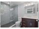 Modern bathroom with gray tile shower, dark vanity, and white toilet at 5500 Denver Ne St, St Petersburg, FL 33703