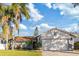 Newly renovated home with a gray exterior, landscaping, and a two-car garage at 6709 Ranger Dr, Tampa, FL 33615