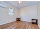 Simple bedroom featuring wood-look floors and natural light at 9650 Starline Dr, Dade City, FL 33525