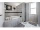 Elegant bathroom with soaking tub, walk-in shower, and tile flooring at 10126 Londonshire Ln, Tampa, FL 33647