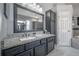 Bathroom with granite countertop, dark cabinets, and large mirror at 10126 Londonshire Ln, Tampa, FL 33647