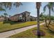 Tan house with palm trees and a sidewalk along the front at 10126 Londonshire Ln, Tampa, FL 33647