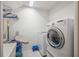 Bright laundry room, complete with washer, dryer, ironing board and storage at 10126 Londonshire Ln, Tampa, FL 33647