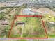 Aerial view of home on large lot with detached garage and pond nearby at 10813 Dixon Dr, Riverview, FL 33579