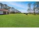 Large backyard with lush grass, trees, and detached garage at 10813 Dixon Dr, Riverview, FL 33579
