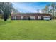 Brick ranch house with attached garage and large grassy yard at 10813 Dixon Dr, Riverview, FL 33579