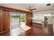 Living room with wood-paneled wall, tile floor, and view into kitchen at 10813 Dixon Dr, Riverview, FL 33579