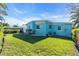 Large grassy backyard with a light teal house at 11435 2Nd E St, Treasure Island, FL 33706