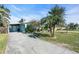 A charming light blue house with a lush green lawn and palm trees at 11435 2Nd E St, Treasure Island, FL 33706