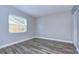 Empty bedroom with neutral walls, wood-look floors, and a window at 11505 Blackbark Dr, Riverview, FL 33579