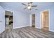 Bedroom with ceiling fan, wood-look floors, and views of the kitchen at 11505 Blackbark Dr, Riverview, FL 33579