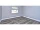 Simple bedroom with wood-look floors and window at 11505 Blackbark Dr, Riverview, FL 33579