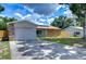 House exterior with stone accents, a driveway, and a fenced yard at 11505 Blackbark Dr, Riverview, FL 33579