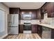 Modern kitchen with stainless steel appliances and dark wood cabinets at 11505 Blackbark Dr, Riverview, FL 33579