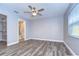 Main bedroom with grey walls, wood-look floors and ceiling fan, and access to bathroom at 11505 Blackbark Dr, Riverview, FL 33579
