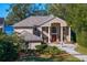 Grand two-story home with a lake view, columns, and manicured landscaping at 11710 N Armenia Ave, Tampa, FL 33612