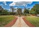 Landscaped backyard with fire pit, seating area, and pathway at 12703 Lake Hills Dr, Riverview, FL 33569