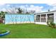 Large backyard with a fun mural and grassy area at 14034 Marguerite Dr, Madeira Beach, FL 33708