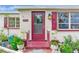 Inviting front entrance with a red door and garden accents at 14034 Marguerite Dr, Madeira Beach, FL 33708