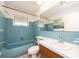 Retro bathroom with blue tile, a bathtub, and a vanity at 14052 89Th Ave, Seminole, FL 33776