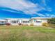 White single story home with green awnings and landscaped lawn at 14052 89Th Ave, Seminole, FL 33776