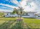 White brick ranch house with teal accents, palm trees, and American flag at 14052 89Th Ave, Seminole, FL 33776