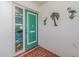Teal front door with stained-glass sidelight and tropical wall decor at 14052 89Th Ave, Seminole, FL 33776