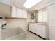 Laundry room with utility sink, cabinets, and hanging rod at 14052 89Th Ave, Seminole, FL 33776