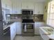 Well-equipped kitchen with stainless steel appliances and tile backsplash at 1701 Pinehurst Rd # 33A, Dunedin, FL 34698