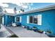 Side view of a charming blue house with white shutters and a partially visible front yard at 17744 1St E St, Redington Shores, FL 33708