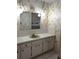 Bathroom with green vanity, patterned wallpaper, and a shower/tub at 237 Orduna Dr, North Port, FL 34287