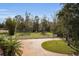 Brick driveway, pond, and lush landscaping at 249 Dogwood Trce, Tarpon Springs, FL 34688