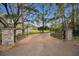 Stone pillars and wrought iron gates open to a brick driveway at 249 Dogwood Trce, Tarpon Springs, FL 34688