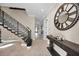 Elegant entryway with a grand staircase, decorative console table, and large clock at 249 Dogwood Trce, Tarpon Springs, FL 34688