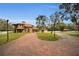 Brick driveway leads to a two-story house with a red tile roof and landscaping at 249 Dogwood Trce, Tarpon Springs, FL 34688