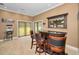 Rustic-chic home bar with three barstools and sliding glass doors at 249 Dogwood Trce, Tarpon Springs, FL 34688