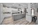 Modern kitchen featuring a gray island, white cabinets, and stainless steel appliances at 249 Dogwood Trce, Tarpon Springs, FL 34688