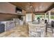 Outdoor kitchen with granite island, built-in grill, and TV at 249 Dogwood Trce, Tarpon Springs, FL 34688