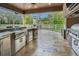 Outdoor kitchen with stainless steel appliances and stonework at 249 Dogwood Trce, Tarpon Springs, FL 34688