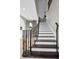 Impressive curved staircase with wrought iron railing and dark wood steps at 249 Dogwood Trce, Tarpon Springs, FL 34688