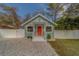 Charming bungalow with a bright teal exterior, white fence, and a red door at 2901 64Th N Ave, St Petersburg, FL 33702