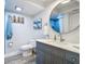 Main bathroom with gray vanity, round mirror, and tiled floor at 322 Boca Ciega Point N Blvd, St Petersburg, FL 33708