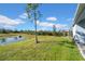 Landscaped backyard with pond and lush green grass at 34104 White Fountain Ct, Wesley Chapel, FL 33545