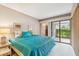 Main bedroom with teal bedding and sliding glass doors at 36750 Us Highway 19 N # 15118, Palm Harbor, FL 34684