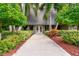 Community building entrance with a paved walkway and lush landscaping at 36750 Us Highway 19 N # 15118, Palm Harbor, FL 34684