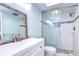 Clean bathroom with a walk-in shower, white vanity, and skylight at 5555 Gulf Blvd # 209, St Pete Beach, FL 33706
