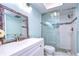 Updated bathroom with a walk-in shower, white vanity, and decorative mirror at 5555 Gulf Blvd # 209, St Pete Beach, FL 33706