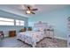 Bedroom with light blue walls, ceiling fan, and water views at 5555 Gulf Blvd # 209, St Pete Beach, FL 33706