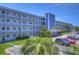 Condo building exterior showcasing light blue facade, parking, and landscaping at 5555 Gulf Blvd # 209, St Pete Beach, FL 33706